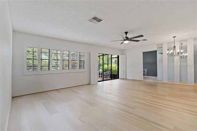1401 Camelot Ct, Palm Harbor, FL 34684 - unfurnished room with wood finished floors, ceiling fan, a chandelier, and a textured ceiling