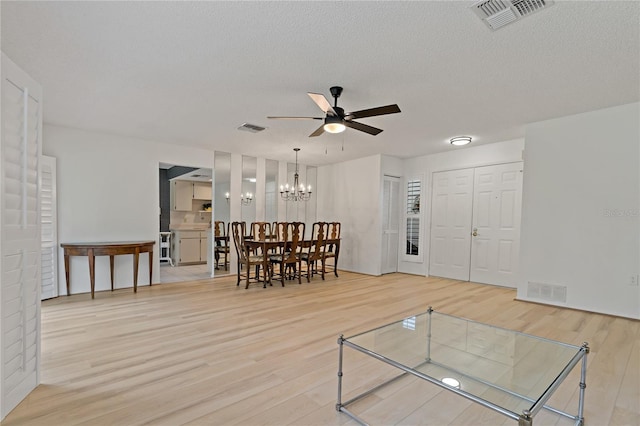 1401 Camelot Ct, Palm Harbor, FL 34684 - living room featuring wood finished floors, ceiling fan, a chandelier, and a textured ceiling