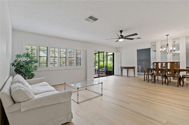 1401 Camelot Ct, Palm Harbor, FL 34684 - living room with light wood-type flooring, ceiling fan, a textured ceiling, and a chandelier