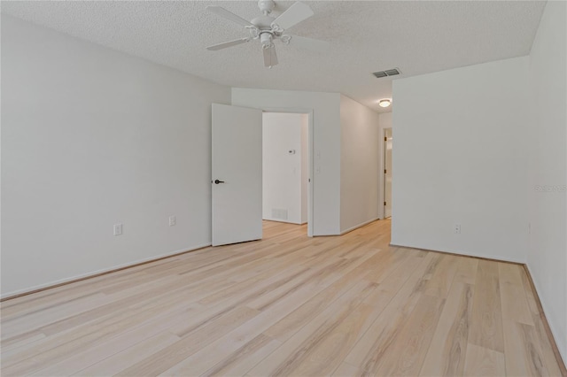 1401 Camelot Ct, Palm Harbor, FL 34684 - unfurnished room featuring light wood-type flooring, a textured ceiling, and a ceiling fan