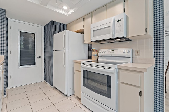 1401 Camelot Ct, Palm Harbor, FL 34684 - kitchen featuring white appliances, light countertops, light tile patterned flooring, and crown molding