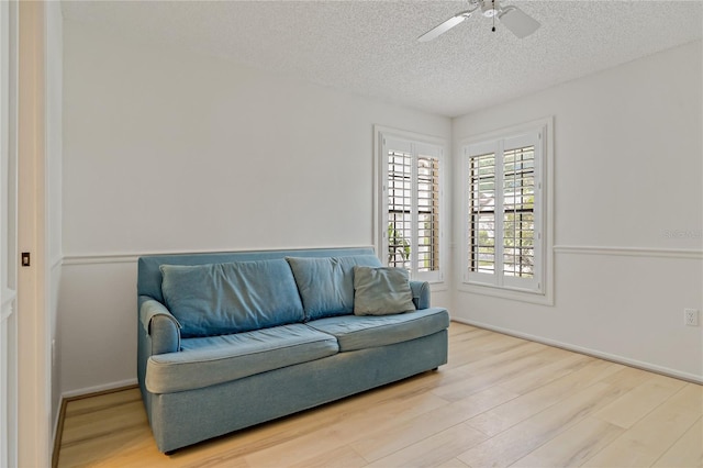1401 Camelot Ct, Palm Harbor, FL 34684 - living area with wood finished floors, a textured ceiling, ceiling fan, and baseboards
