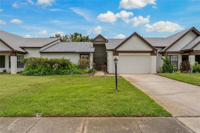 1401 Camelot Ct, Palm Harbor, FL 34684 - view of front of home featuring stucco siding, a garage, concrete driveway, and a front yard
