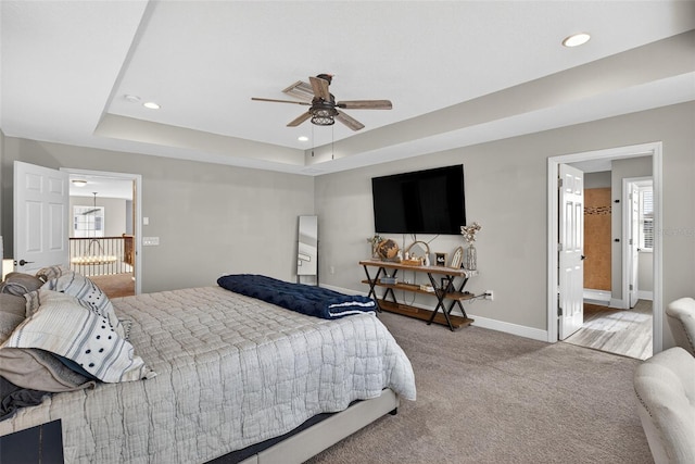 7570 Sweeter Tide Trl, Wesley Chapel, FL 33545 - carpeted bedroom featuring recessed lighting, a tray ceiling, multiple windows, a ceiling fan, and connected bathroom