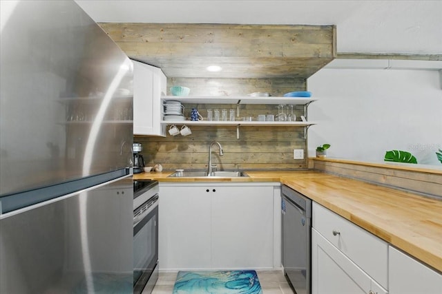 511 1st St, Cedar Key, FL 32625 - kitchen featuring appliances with stainless steel finishes, butcher block countertops, open shelves, and white cabinetry