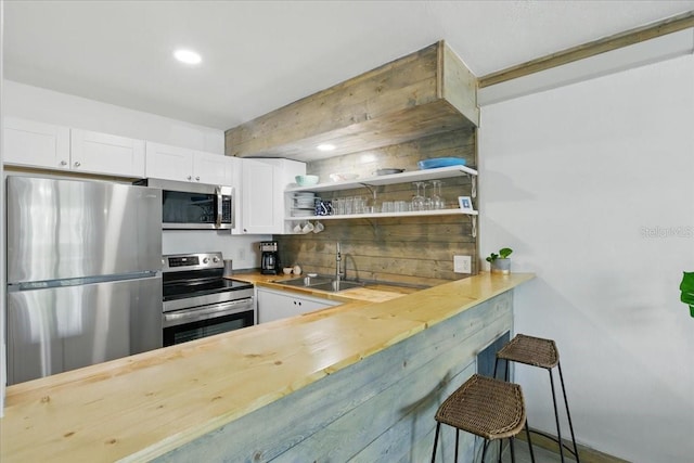 511 1st St, Cedar Key, FL 32625 - kitchen with appliances with stainless steel finishes, wood counters, white cabinets, open shelves, and recessed lighting