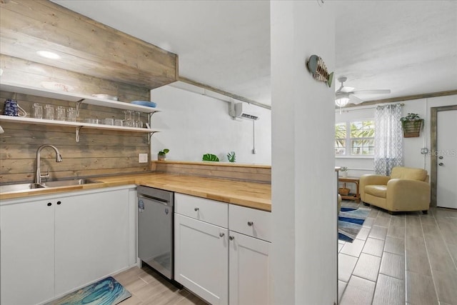 511 1st St, Cedar Key, FL 32625 - kitchen featuring open shelves, stainless steel dishwasher, light wood finished floors, white cabinets, and wooden counters