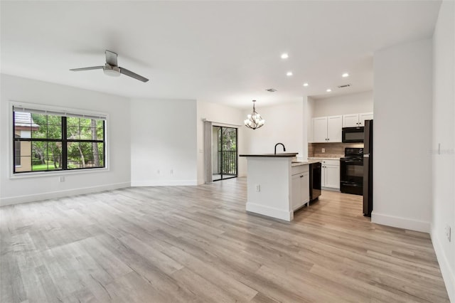 2171 Portofino Pl Unit 27-2725, Palm Harbor, FL 34683 - kitchen with black appliances, open floor plan, a chandelier, recessed lighting, and light wood-style flooring