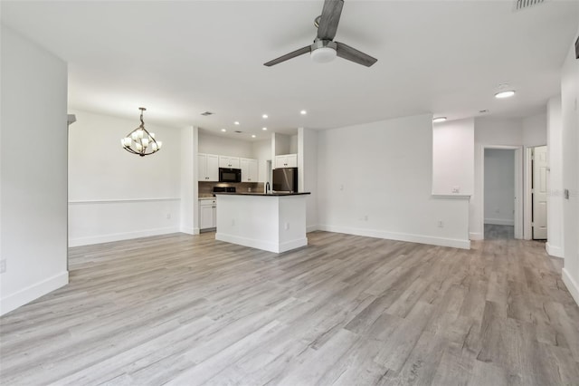 2171 Portofino Pl Unit 27-2725, Palm Harbor, FL 34683 - unfurnished living room with light wood finished floors, a ceiling fan, baseboards, a chandelier, and recessed lighting