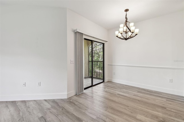2171 Portofino Pl Unit 27-2725, Palm Harbor, FL 34683 - spare room with a chandelier, baseboards, and wood finished floors