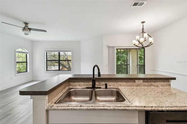 2171 Portofino Pl Unit 27-2725, Palm Harbor, FL 34683 - kitchen with a sink, wood finished floors, a chandelier, decorative light fixtures, and stainless steel dishwasher