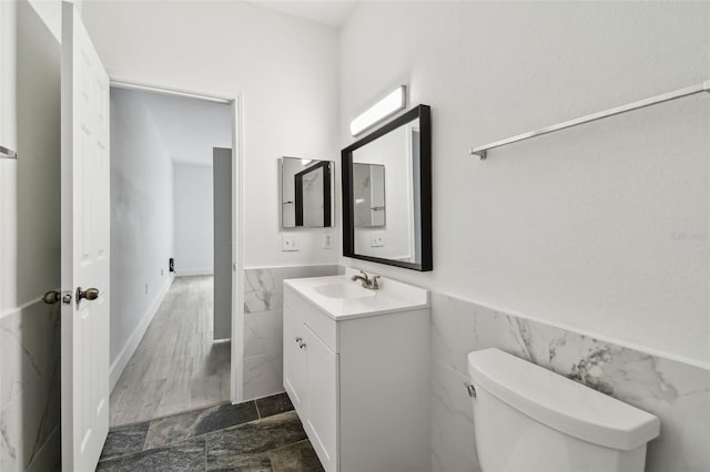 2171 Portofino Pl Unit 27-2725, Palm Harbor, FL 34683 - half bath with tile walls, vanity, a wainscoted wall, and toilet