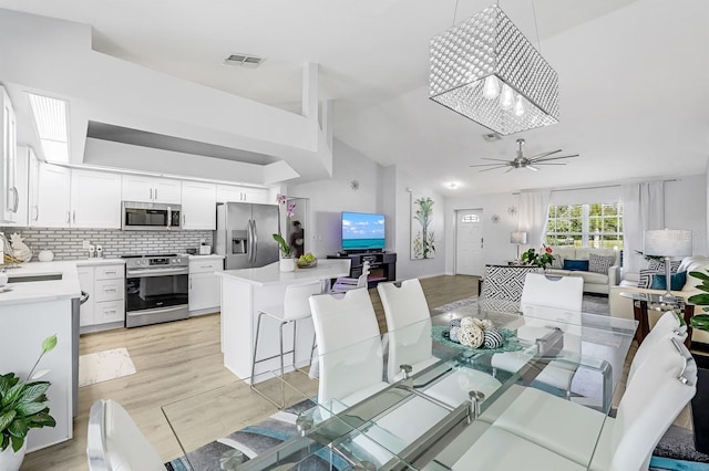 28 SW 21st Ave, Cape Coral, FL 33991 - dining area featuring light wood-type flooring, vaulted ceiling, and ceiling fan