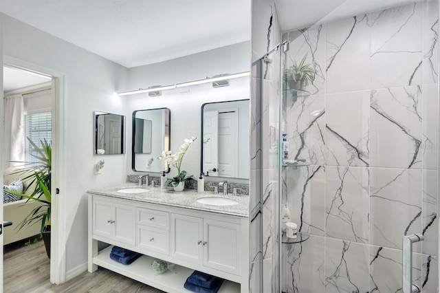 28 SW 21st Ave, Cape Coral, FL 33991 - bathroom featuring double vanity, a marble finish shower, and wood finished floors