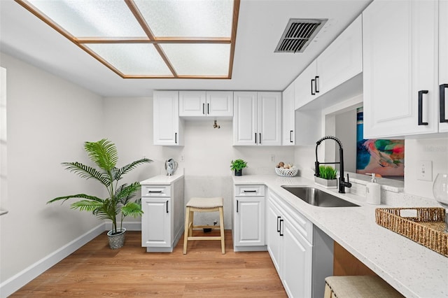 2460 Northside Dr Unit 802, Clearwater, FL 33761 - kitchen featuring light wood-type flooring, white cabinetry, and light stone counters