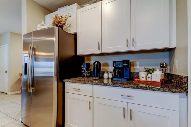 9334 Lemon Drop Loop, Sun City Center, FL 33573 - kitchen with stainless steel fridge, dark stone countertops, light tile patterned floors, and white cabinets