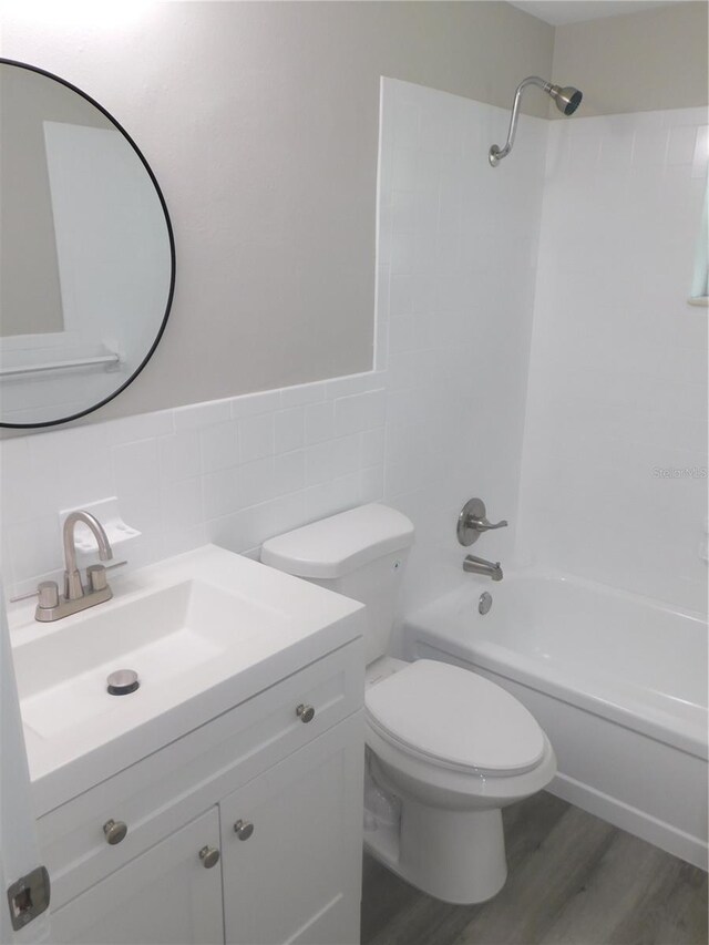 4417 Kohler St, New Port Richey, FL 34652 - full bath with tile walls, shower / washtub combination, vanity, toilet, and wood finished floors