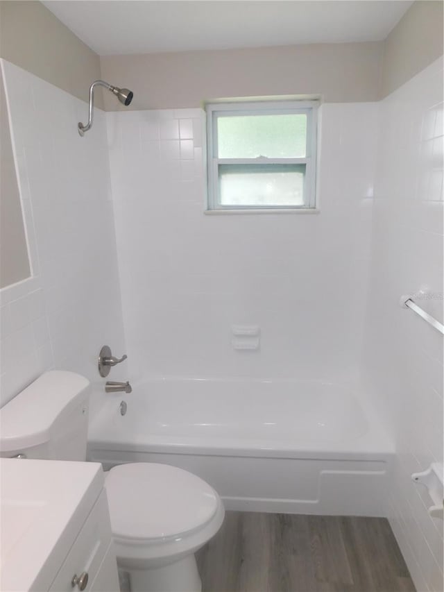 4417 Kohler St, New Port Richey, FL 34652 - bathroom with toilet, shower / bathtub combination, vanity, wood finished floors, and tile walls