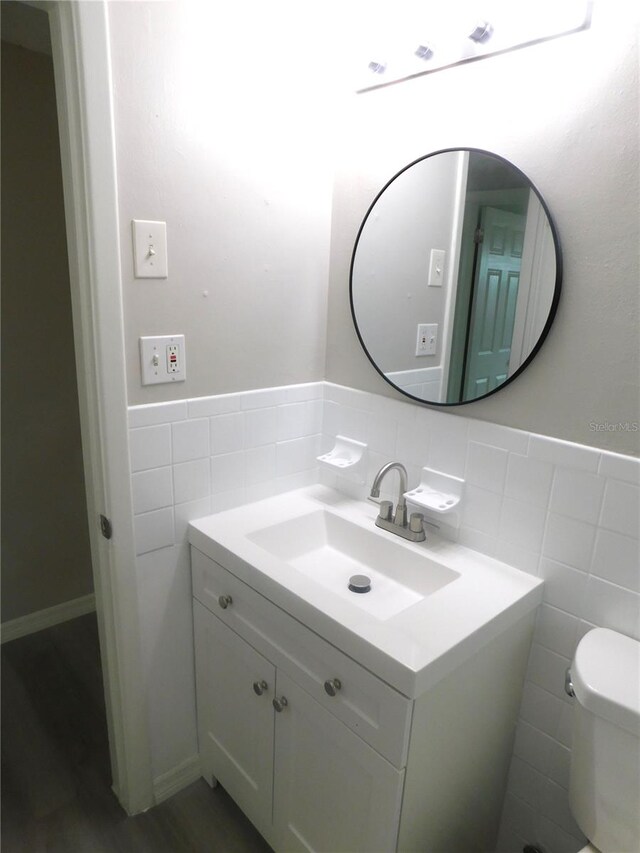 4417 Kohler St, New Port Richey, FL 34652 - bathroom with tile walls, vanity, toilet, and wainscoting