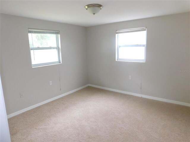 4417 Kohler St, New Port Richey, FL 34652 - empty room with healthy amount of natural light, carpet, and baseboards