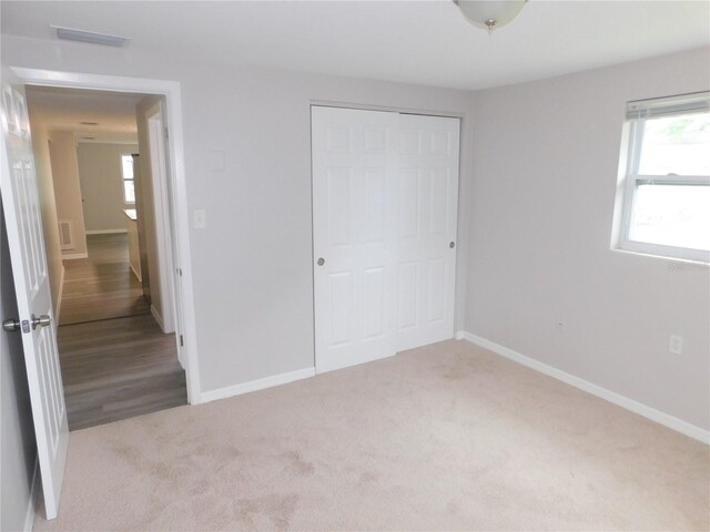 4417 Kohler St, New Port Richey, FL 34652 - unfurnished bedroom featuring a closet, carpet flooring, baseboards, and multiple windows