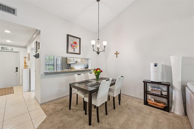 4735 Winslow Beacon Unit 14, Sarasota, FL 34235 - dining space featuring a chandelier, carpet, tile patterned flooring, and vaulted ceiling