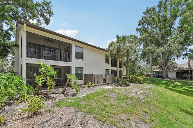 4735 Winslow Beacon Unit 14, Sarasota, FL 34235 - back of house featuring ceiling fan, stucco siding, and a lawn