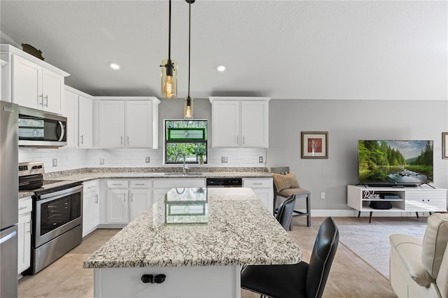 12004 Legacy Bright St, Riverview, FL 33578 - kitchen featuring appliances with stainless steel finishes, decorative backsplash, a kitchen bar, light stone countertops, and recessed lighting