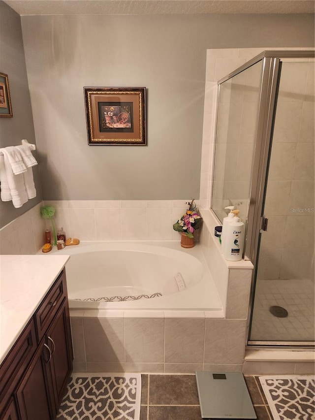 373 Intrepid Way, Indialantic, FL 32903 - bathroom with a bath, vanity, a shower stall, tile patterned flooring, and a textured ceiling
