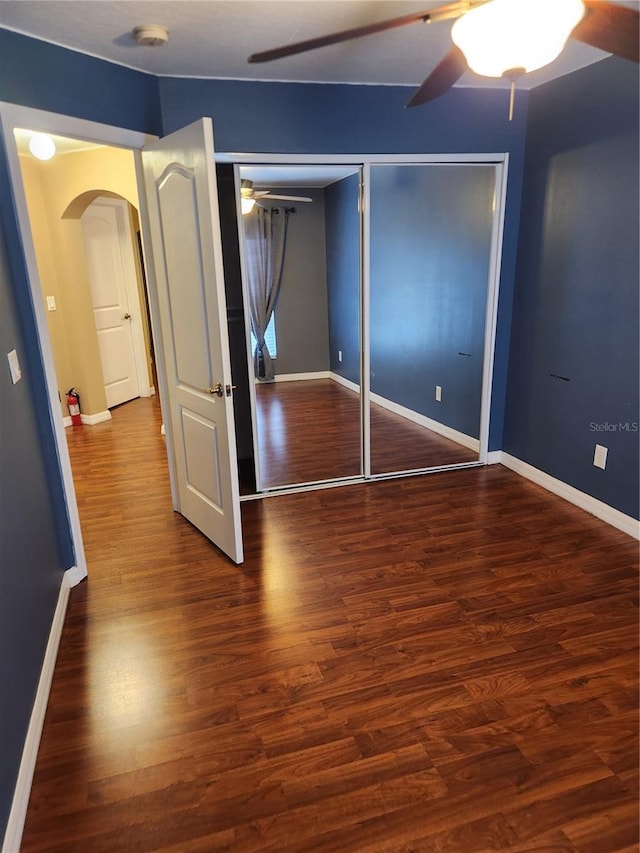 373 Intrepid Way, Indialantic, FL 32903 - unfurnished bedroom featuring arched walkways, baseboards, wood finished floors, and a ceiling fan