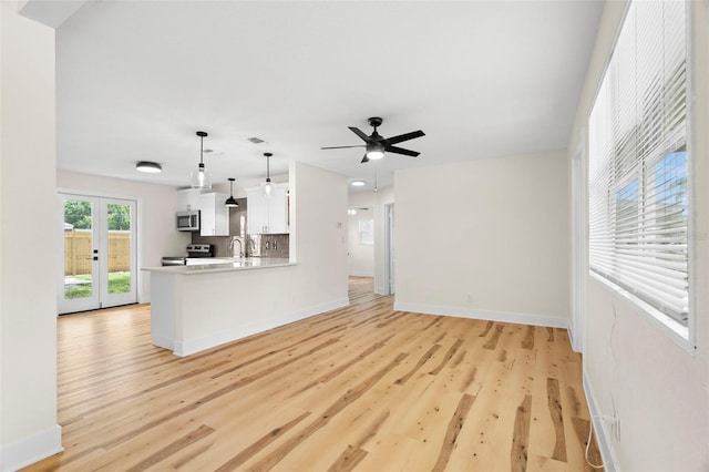 4414 W Oklahoma Ave, Tampa, FL 33616 - unfurnished living room with light wood-style flooring, ceiling fan, and french doors