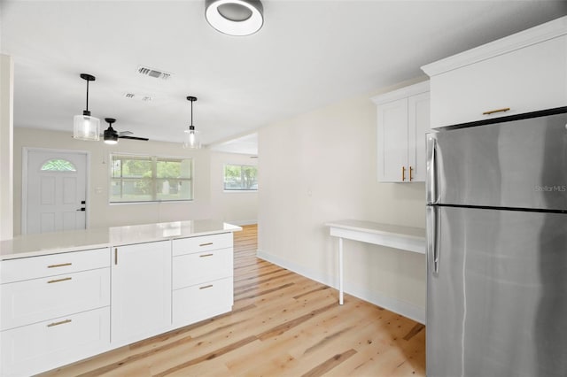 4414 W Oklahoma Ave, Tampa, FL 33616 - kitchen featuring freestanding refrigerator, a ceiling fan, light wood-type flooring, white cabinets, and light countertops