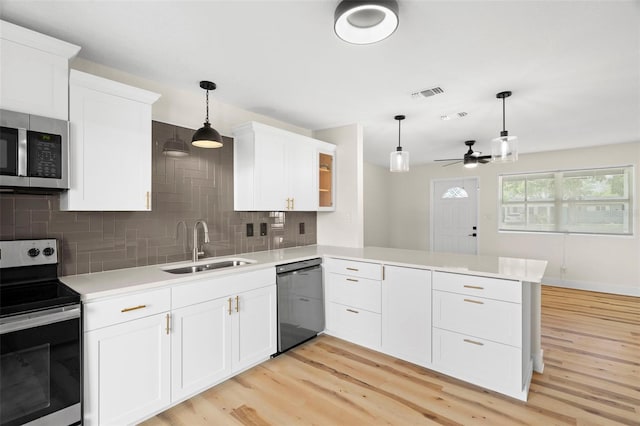 4414 W Oklahoma Ave, Tampa, FL 33616 - kitchen featuring stainless steel appliances, a peninsula, ceiling fan, light wood-style floors, and light countertops
