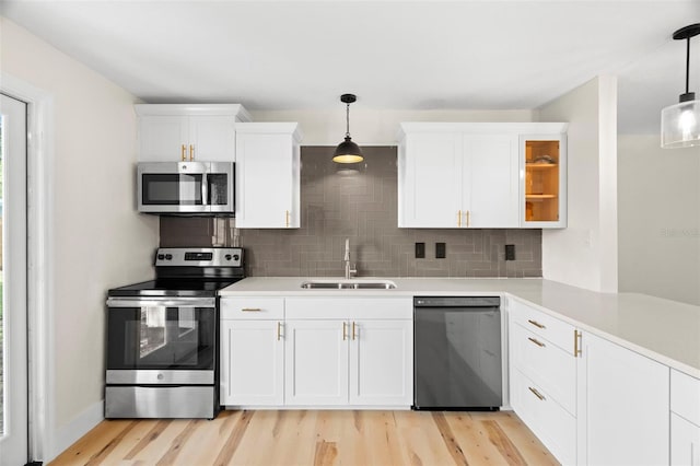 4414 W Oklahoma Ave, Tampa, FL 33616 - kitchen featuring stainless steel appliances, backsplash, light wood-type flooring, and white cabinets