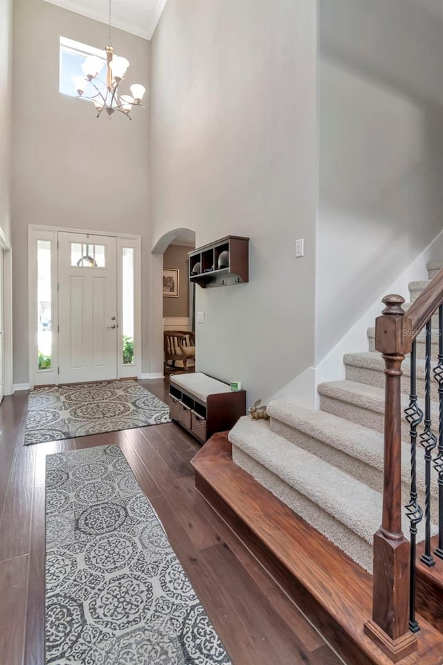 26972 Evergreen Chase Dr, Wesley Chapel, FL 33544 - foyer entrance with arched walkways, stairway, a towering ceiling, ornamental molding, and dark wood-type flooring
