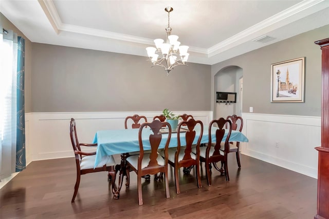 26972 Evergreen Chase Dr, Wesley Chapel, FL 33544 - dining area featuring a raised ceiling, a chandelier, wainscoting, arched walkways, and dark wood-style flooring
