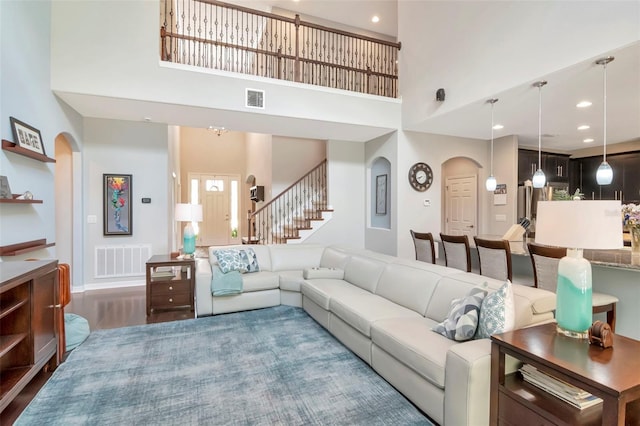 26972 Evergreen Chase Dr, Wesley Chapel, FL 33544 - living room featuring arched walkways, a high ceiling, stairway, wood finished floors, and recessed lighting