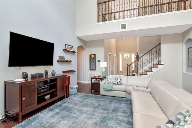 26972 Evergreen Chase Dr, Wesley Chapel, FL 33544 - living room with arched walkways, a towering ceiling, stairs, and wood finished floors