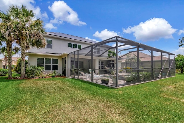 26972 Evergreen Chase Dr, Wesley Chapel, FL 33544 - rear view of house with stucco siding, a patio area, a lawn, roof mounted solar panels, and a lanai