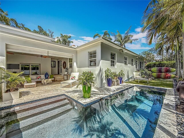 301 23rd Ave NE, Saint Petersburg, FL 33704 - back of house featuring a patio area, stucco siding, a ceiling fan, an outdoor living space, and an outdoor pool