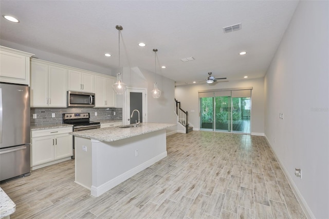17834 Althea Blue Pl, Lutz, FL 33558 - kitchen featuring appliances with stainless steel finishes, a sink, light wood finished floors, backsplash, and recessed lighting