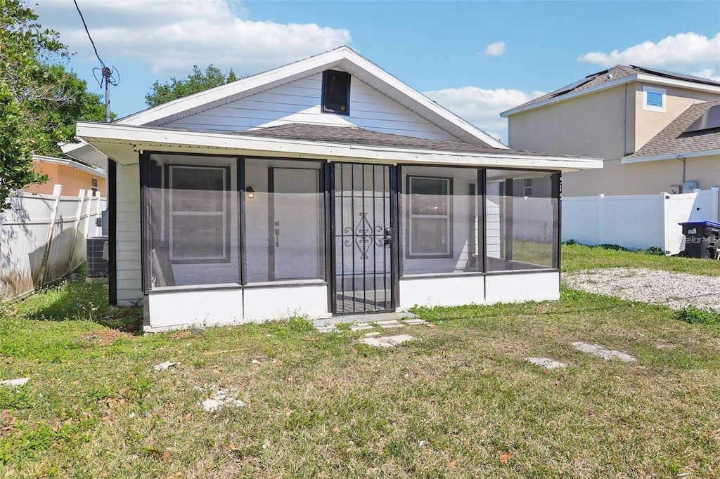 515 9th St, Winter Garden, FL 34787 - view of front of property featuring a sunroom, roof with shingles, and central AC unit