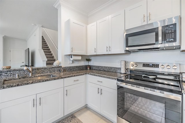 36414 Well Hill Way, Zephyrhills, FL 33541 - kitchen featuring appliances with stainless steel finishes, ornamental molding, white cabinetry, dark stone countertops, and light tile patterned floors