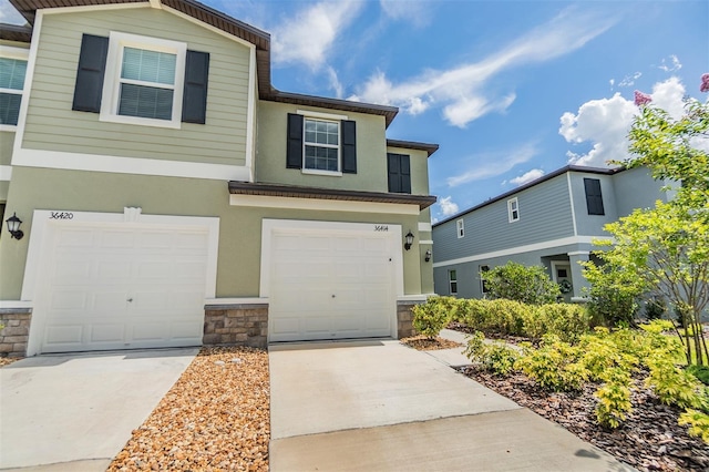 36414 Well Hill Way, Zephyrhills, FL 33541 - view of front of home with stone siding, concrete driveway, a garage, and stucco siding