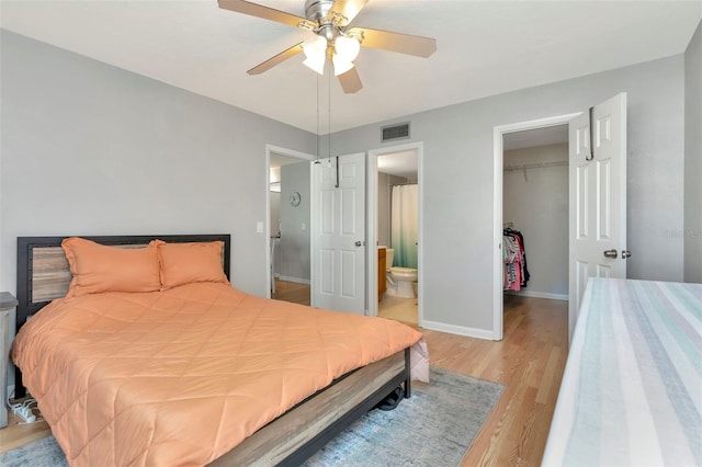 14130 Rosemary Ln Unit 3202, Largo, FL 33774 - bedroom featuring light wood finished floors, a walk in closet, a closet, ensuite bathroom, and a ceiling fan