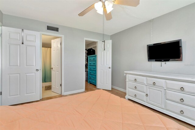 14130 Rosemary Ln Unit 3202, Largo, FL 33774 - bedroom featuring a spacious closet, ensuite bath, ceiling fan, and a closet