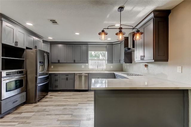 8330 Lafitte Dr, Hudson, FL 34667 - kitchen featuring stainless steel appliances, a peninsula, gray cabinets, recessed lighting, and pendant lighting
