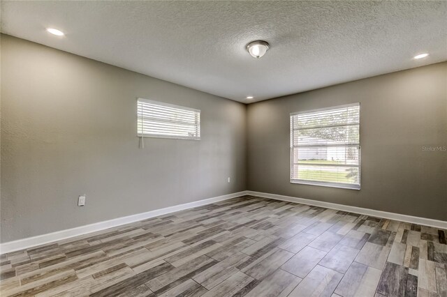 8330 Lafitte Dr, Hudson, FL 34667 - unfurnished room featuring plenty of natural light, wood finished floors, baseboards, a textured ceiling, and recessed lighting