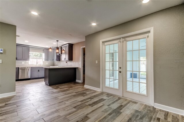 8330 Lafitte Dr, Hudson, FL 34667 - kitchen featuring stainless steel dishwasher, a chandelier, light wood finished floors, light countertops, and a peninsula