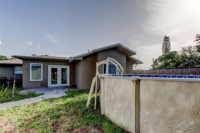 8330 Lafitte Dr, Hudson, FL 34667 - rear view of property featuring stucco siding and french doors